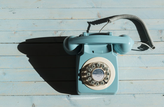 A blue retro telephone on a blue background