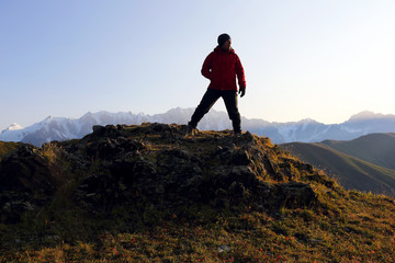 Obraz premium tourist stands on a hill in a mountainous area in Georgia.