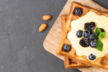 Crispy wafers with cream and berries, horizontal, top view, black background, close-up, soft focus