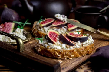 Foto op Plexiglas toast met kwark en vijgen op een houten dienblad © lenakorzh