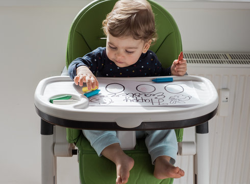 Child coloring in highchair