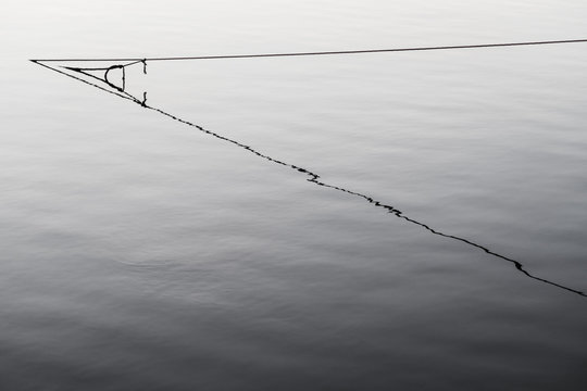 Rope leading into water with its reflection
