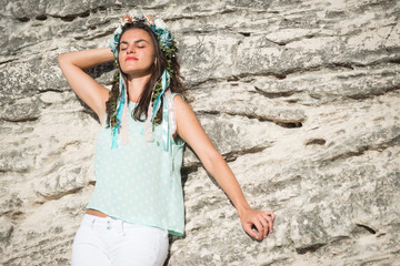 Young woman in blue shirt and white shorts with flower head band enjoying the moment