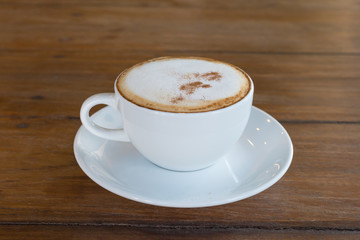 cappuccino in white coffee cup on wood table, coffee time.