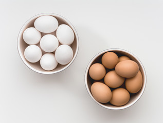Bowls of white and brown eggs