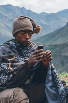 Rural African Basotho herdsman using a mobile phone