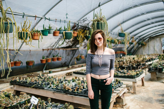 Portrait of a young woman in a cactus greenhouse