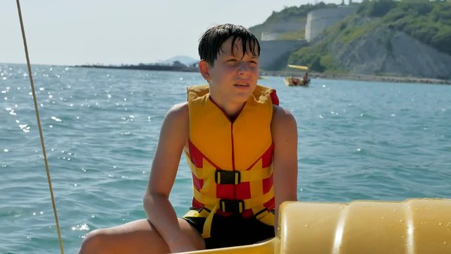 boy teenager on a yacht. sailor bathe in the open ocean water on catamaran