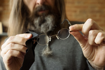 Man checking how clean his eyeglasses are