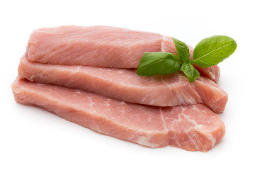Fresh pork fillet with basil on a white background.