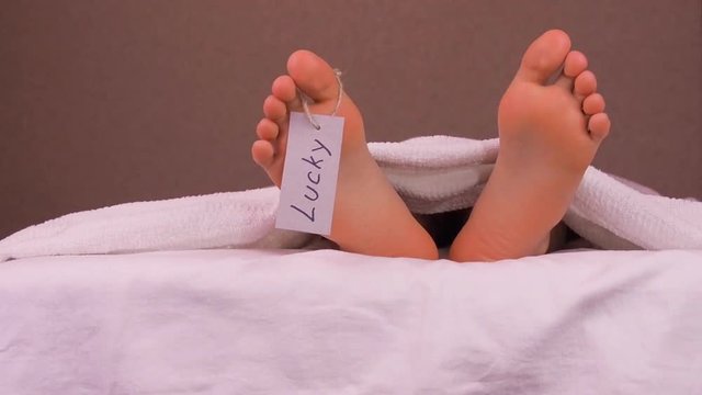 Legs of the deceased with a tag. A tag on my feet with an inscription lucky.