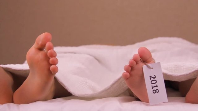 Legs of the deceased with a tag 2017. Wiggling small feet with a tag 2018. Big feet with a tag 2017 and small with a tag 2018.