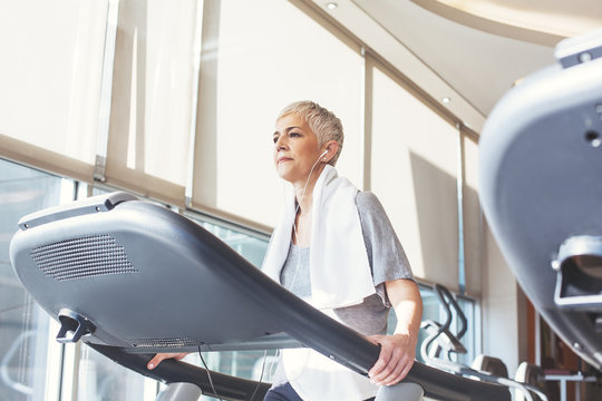 Woman Listening to Music While Walking on a Treadmill