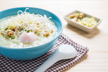 Thai rice porridge with pork and spoon on wood table,pork congee