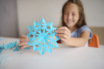 Making of snowflakes from blue paper.