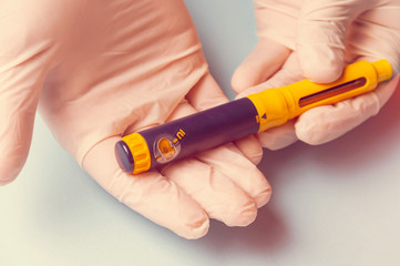 A man in medical gloves holds a syringe for subcutaneous injection of hormonal drugs in the IVF protocol in vitro fertilization Pregnancy, help to his wife. Toning