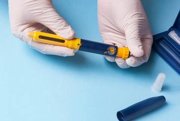 A man in medical gloves holds a syringe for subcutaneous injection of hormonal drugs in the IVF protocol in vitro fertilization Pregnancy, help to his wife.