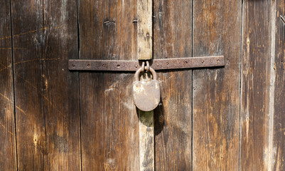 Old padlock on wooden door