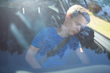 Teenage boy sleeping in the car