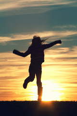 a child jumping at sunset.