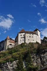 Fototapeta na wymiar Burg Gutenberg thront auf Hügel vor den Bergen, in der Gemeinde Balzers im Fürstentum Liechtenstein 
