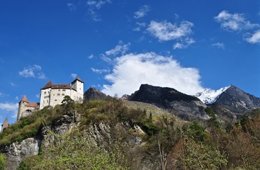 Fototapeta na wymiar Burg Gutenberg thront auf Hügel vor den Bergen, in der Gemeinde Balzers im Fürstentum Liechtenstein 