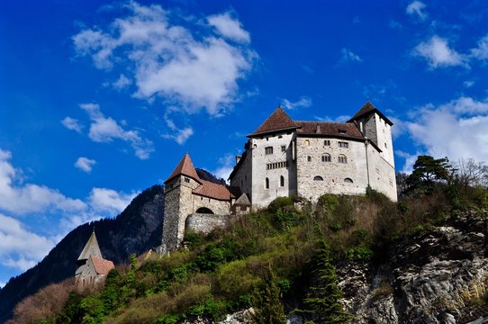 Burg Gutenberg thront auf 
Hügel vor den Bergen, in der Gemeinde Balzers im Fürstentum Liechtenstein 