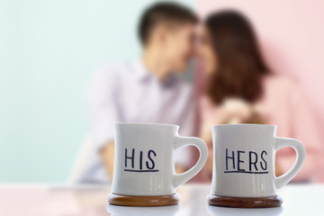 Couple lover blurry in background with two coffee cups 