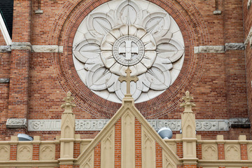 Cross, circle and floral details on St Willebrord Catholic Church in Green Bay, WI - obrazy, fototapety, plakaty