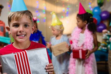 Portrait of happy boy showing gift