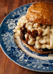 Mac and Cheese sandwich with brisket and bbq sauce on a blue vintage plate