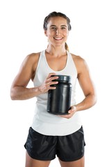Portrait of smiling female athlete holding supplement jar
