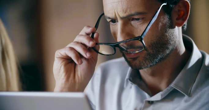 Man wearing eyeglasses using tablet.Corporate business team work office meeting.Three caucasian businessman and businesswoman people group talking strategy together.Collaboration,growing,success.4k