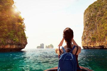 Happy woman traveler with backpack by boat enjoying at Maya bay Phi Phi Islands andaman sea Krabi.
