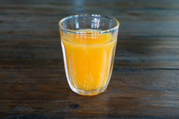 orange juice glass on wood table