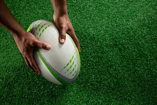 High Angle View Of Hands Holding Rugby Ball