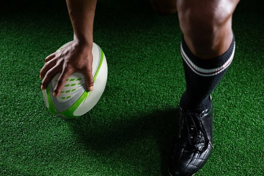 High angle view sportsman kicking rugby ball