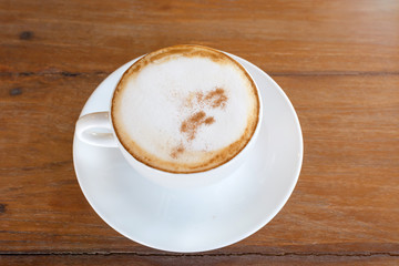 cappuccino in white coffee cup on wood table, coffee time