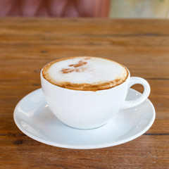 cappuccino in white coffee cup on wood table, coffee time