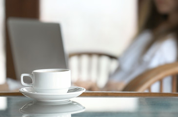 Cup of tasty hot coffee on table in cafe