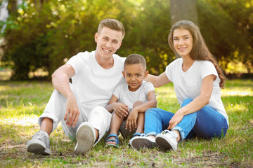 Fototapeta premium Young family with adopted African American boy outdoors