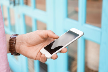 Man holding smartphone outdoors
