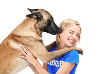 Dog licking young female volunteer, isolated on white. Concept of volunteering and animal shelters