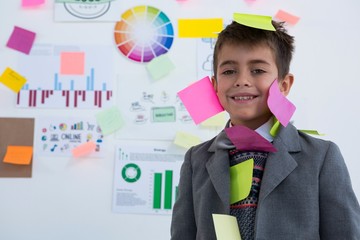 Boy as business executive with sticky notes on his body - Powered by Adobe