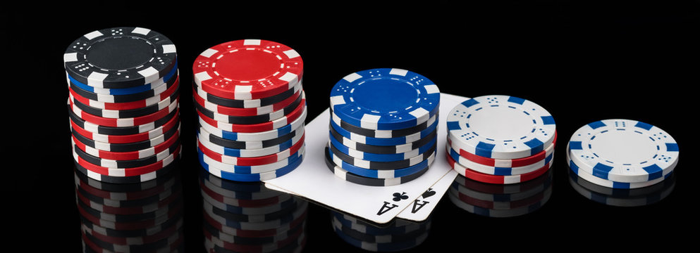 chips and poker cards lie in length on a black background with reflection