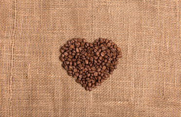 Coffee grain heart on fabric textured brown background