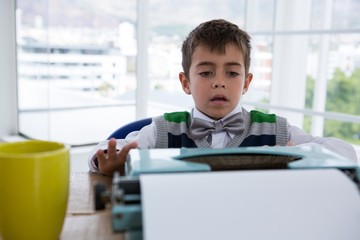 Boy as business executive using typewriter