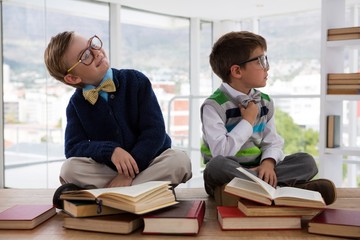 Kids as business executive sitting on a table - obrazy, fototapety, plakaty