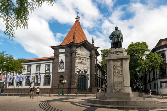 FUNCHAL, MADEIRA, PORTUGAL - SEPTEMBER 10, 2017: Joao Gon&ccedil;alves Zarco statue in front of the bank of Portugal