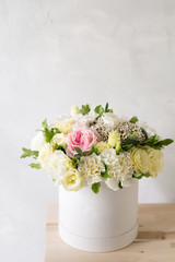 Beautiful tender bouquet of flowers in white box on light ackground with space for text